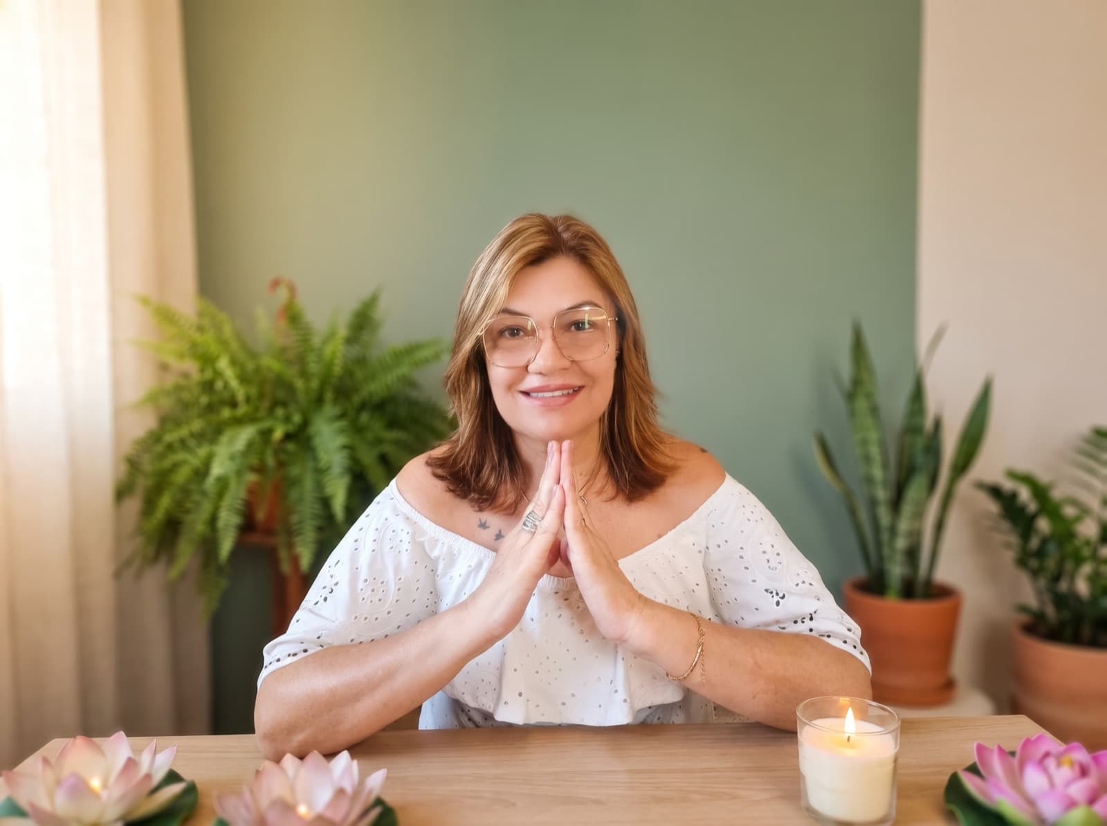 Cida Gomes, terapeuta holística, em gesto de acolhimento em seu espaço de atendimento